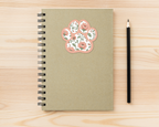 Blush Meadow Floral Paw Print Sticker on a spiral notebook