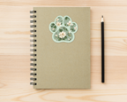 Magnolia Sage Floral Paw Print Sticker on a spiral notebook