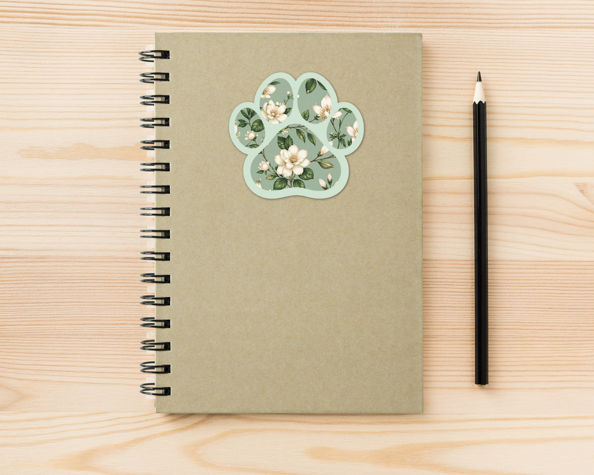 Magnolia Sage Floral Paw Print Sticker on a spiral notebook