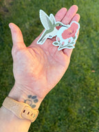 Ruby-throated Hummingbird sticker with a pink hibiscus flower resting in an open palm outdoors