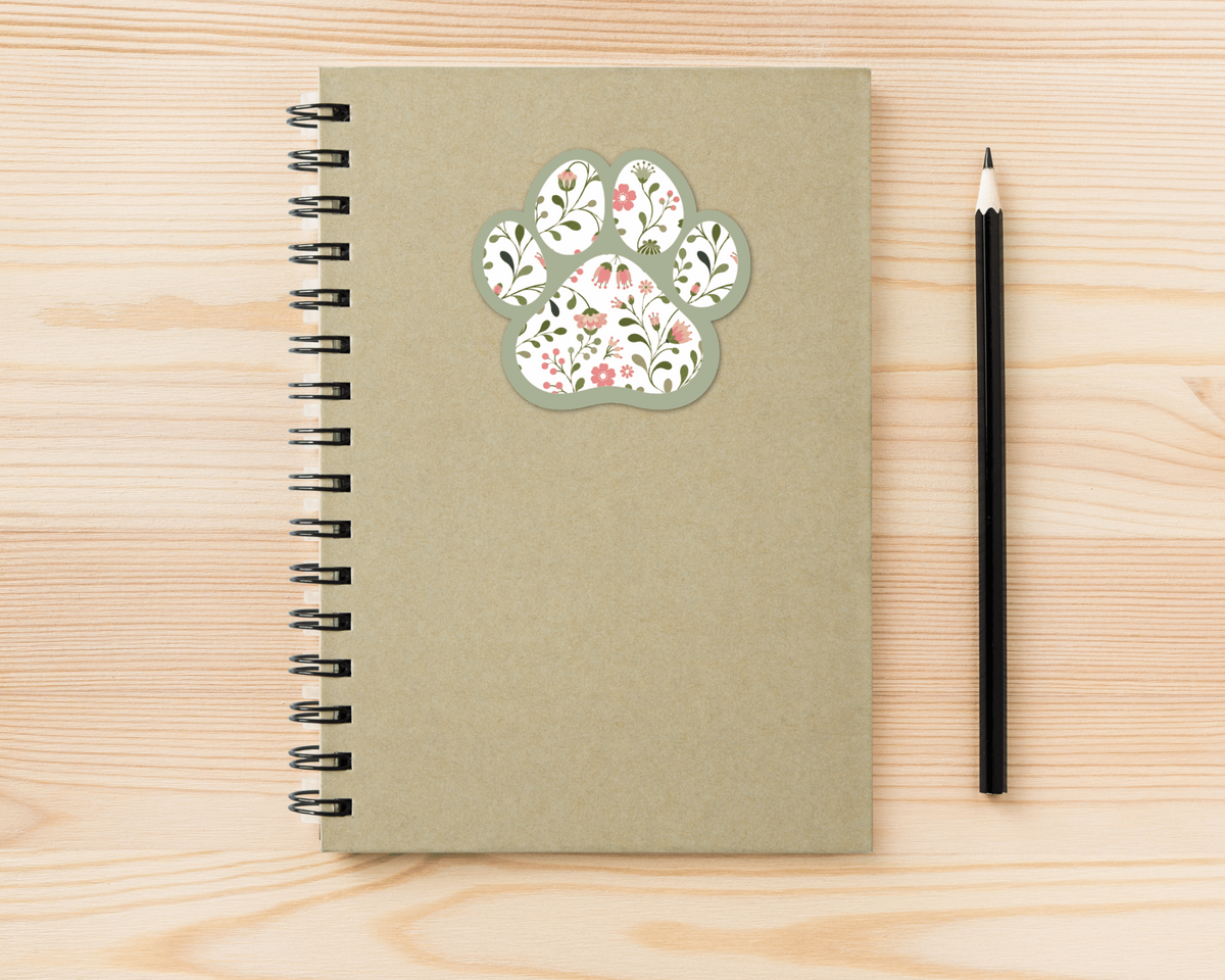 Sage Garden Floral Paw Print Sticker on a spiral notebook