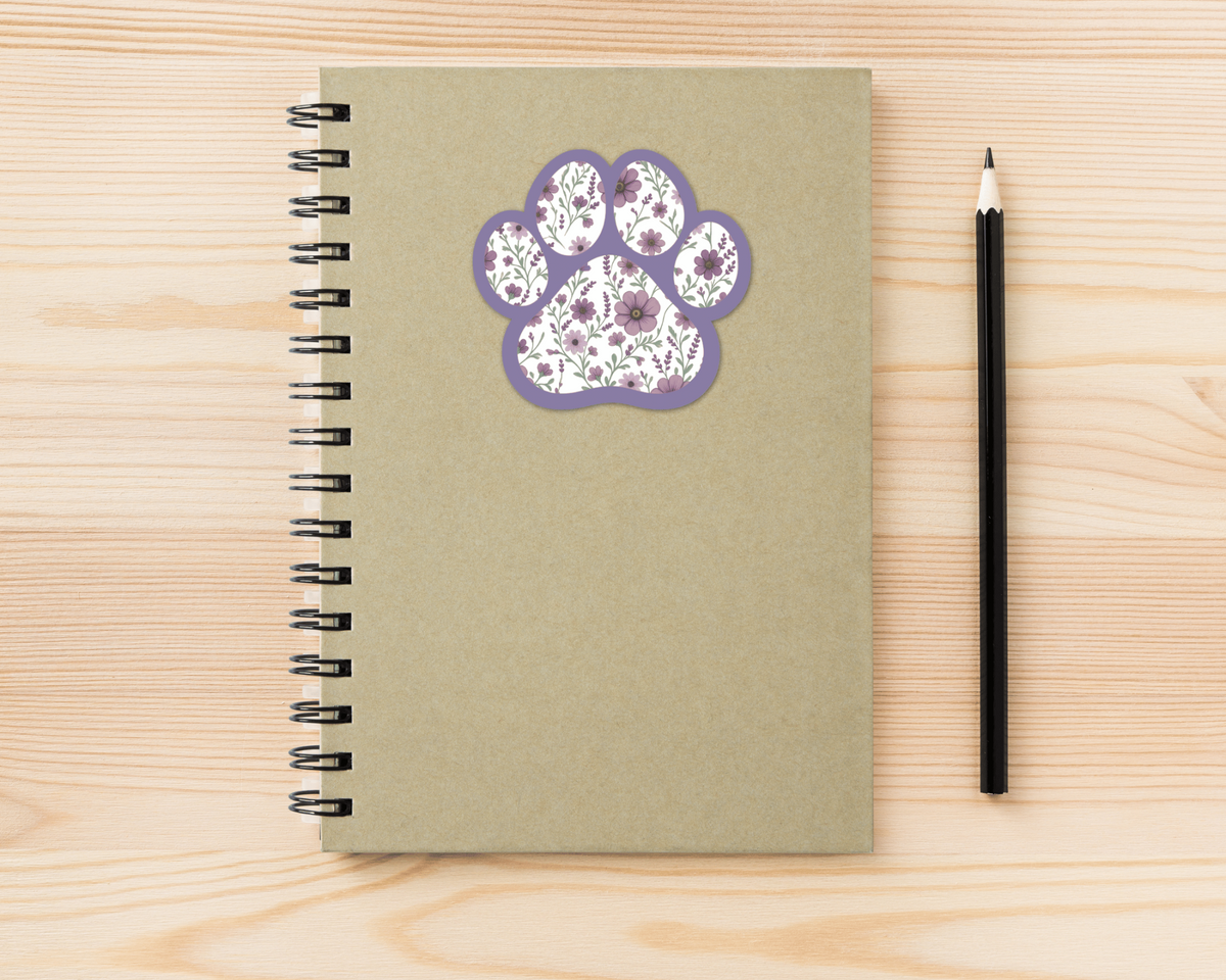 Violet Garden Floral Paw Print Sticker on a spiral notebook